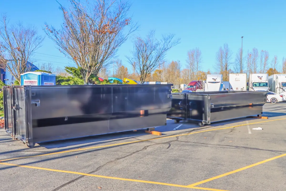 Professional dumpster rental service with roll-off container on residential driveway in Beverly